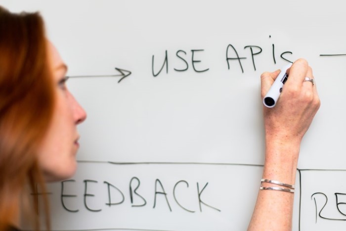 Software developer working out a solution on a whiteboard