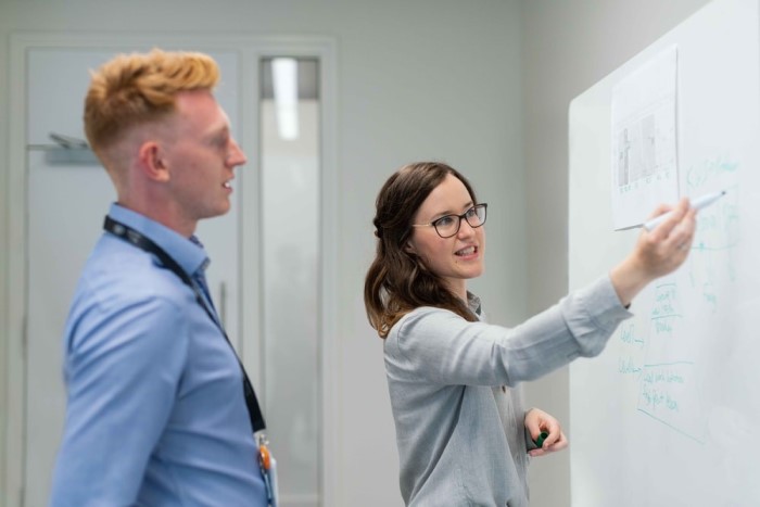 Female software engineer explaining something to a colleague